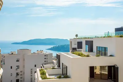 a view of two white buildings and the ocean at The Royal Summer & Spa in Becici