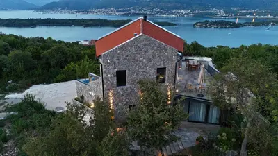 a house on a hill with a view of the water at Villa Diamonte in Ðuraševići