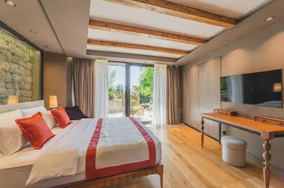 a bedroom with a bed and a desk and a television at Villa Diamonte in Ðuraševići