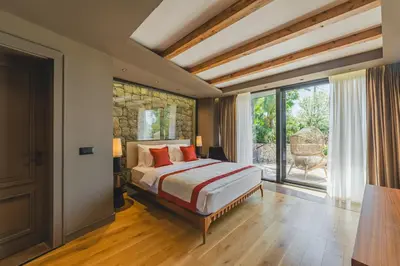 a bedroom with a bed and a large window at Villa Diamonte in Ðuraševići
