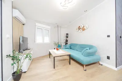 a living room with a blue couch and a table at Apartment Cataleya in Budva