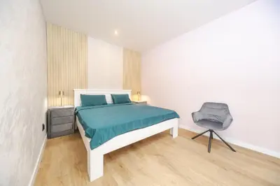 a bedroom with a bed and a chair in it at Apartment Cataleya in Budva