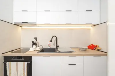 a kitchen with white cabinets and a sink at Apartment Cataleya in Budva