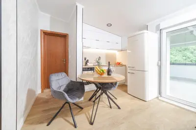 a kitchen and dining room with a table and chairs at Apartment Cataleya in Budva