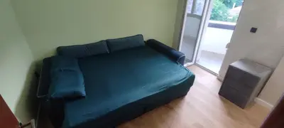 a green bed in a room with a sliding glass door at Apartment Cataleya in Budva
