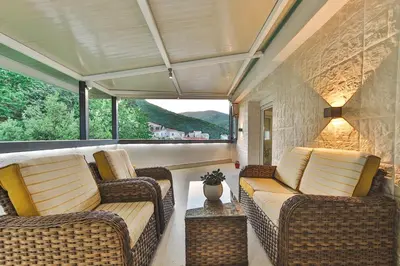 a screened in porch with two couches and a table at Apartment Cataleya in Budva
