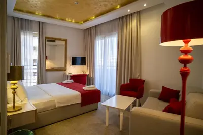 a hotel room with a bed and a chair at Hotel Atina in Budva