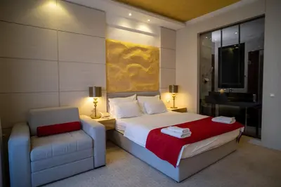 a hotel room with a bed and a chair at Hotel Atina in Budva