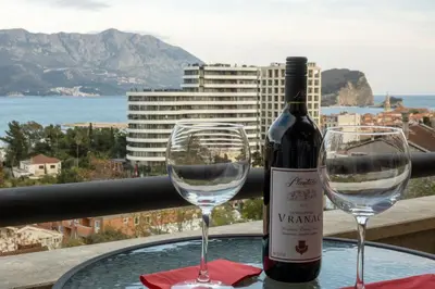 a bottle of wine and two glasses on a table at Hotel Atina in Budva