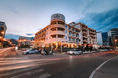 a city building with cars parked in a parking lot at City Apartments in Budva