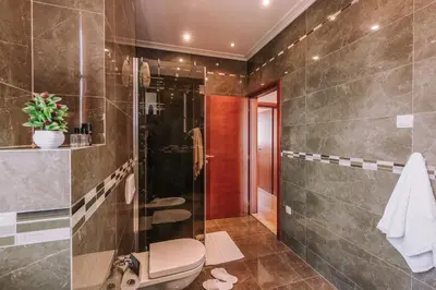 a bathroom with a toilet and a glass shower at City Apartments in Budva