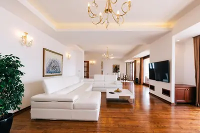 a living room with white furniture and a chandelier at City Apartments in Budva