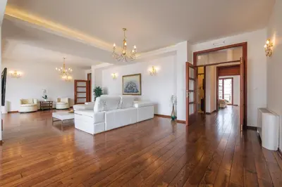 a living room with a white couch and wood floors at City Apartments in Budva