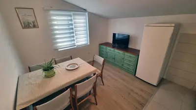 a dining room with a table with chairs and a television at Apartment Folic Sutomore in Sutomore