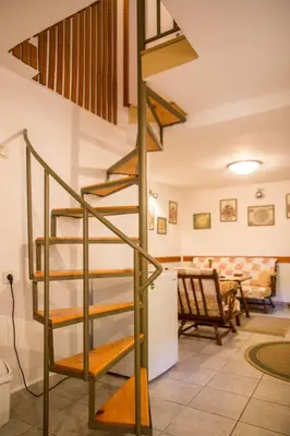 a spiral staircase in a living room with a table at Azur Apartment in Budva