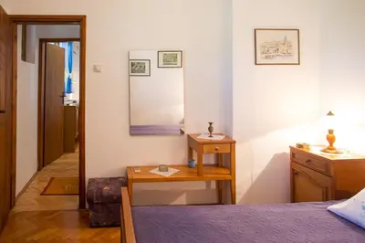 a bedroom with a bed and a table and a mirror at Azur Apartment in Budva