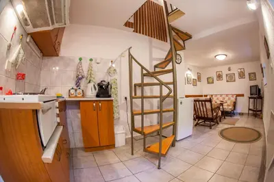 a kitchen with a spiral staircase and a living room at Azur Apartment in Budva