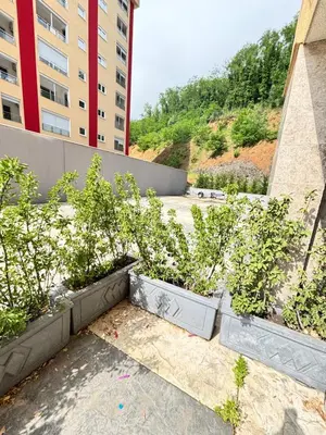 a group of plants in pots in front of a building at Becici Garden in Becici