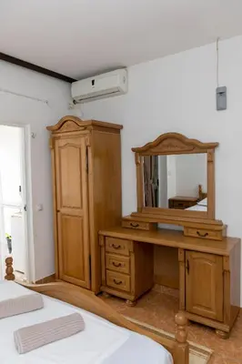 a bedroom with a wooden dresser and a mirror at Villa Duraku in Ulcinj