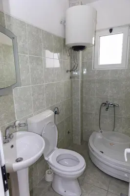 a bathroom with a white toilet and a sink at Villa Duraku in Ulcinj