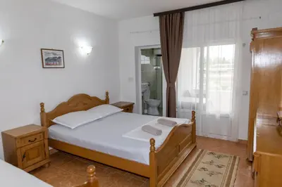 a bedroom with a bed and a bathroom with a window at Villa Duraku in Ulcinj