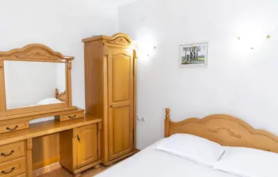 a bedroom with a bed and a dresser and a mirror at Villa Duraku in Ulcinj