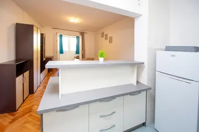 a kitchen with white cabinets and a white refrigerator at Palm street apartment near Dukley beach in Budva