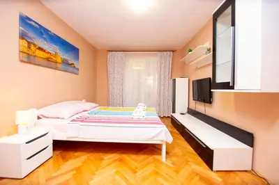 a bedroom with a bed and a flat screen tv at Palm street apartment near Dukley beach in Budva