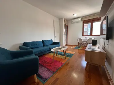a living room with a blue couch and a table at DOWNTOWN apartment Old Town in Podgorica