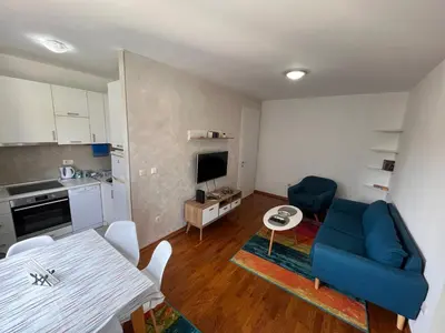 a living room with a blue couch and a table at DOWNTOWN apartment Old Town in Podgorica