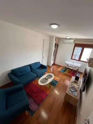 a living room with a blue couch and a table at DOWNTOWN apartment Old Town in Podgorica