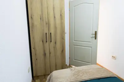 a bedroom with a door and a bed and a closet at Green Garden in Tivat