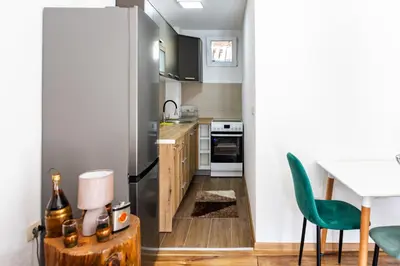 a small kitchen with a table and a green chair at Green Garden in Tivat