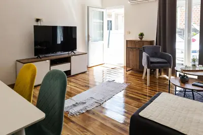 a living room with a flat screen tv on a entertainment center at Green Garden in Tivat