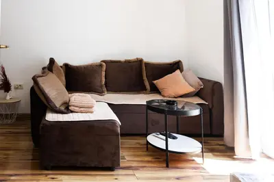 a living room with a brown couch and a table at Green Garden in Tivat