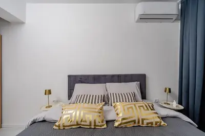 a bedroom with a bed with yellow and white pillows at Alpha Mare in Bar