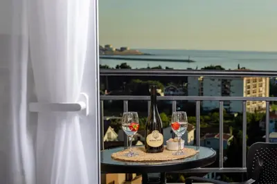 a table with wine bottles and glasses on a balcony at Alpha Mare in Bar