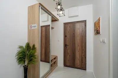 a hallway with a wooden door and a potted plant at Alpha Mare in Bar