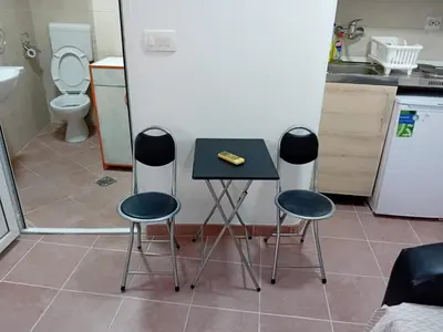 a kitchen with a table and three stools at Mota saste mini duplex in Sveti Stefan