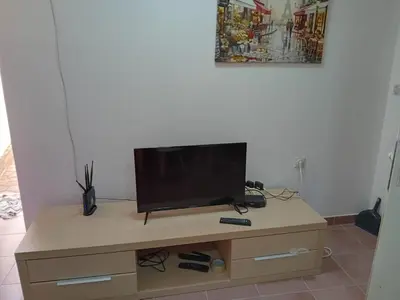 a tv sitting on top of a wooden cabinet at Mota saste mini duplex in Sveti Stefan