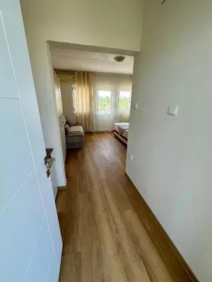 an empty living room with a hallway with a hard wood floor at Villa Paris in Donji Štoj