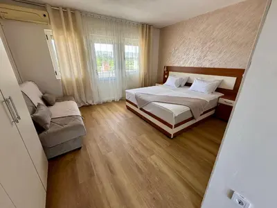 a bedroom with a bed and a couch in it at Villa Paris in Donji Štoj