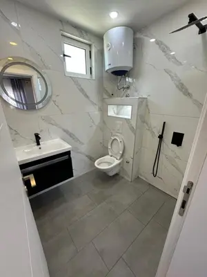 a white bathroom with a toilet and a sink at Villa Paris in Donji Štoj