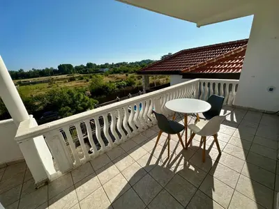 a patio with a table and chairs on a balcony at Villa Paris in Donji Štoj