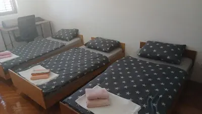 a room with two beds and a table with a cake at Apartman Lastva in Lastva