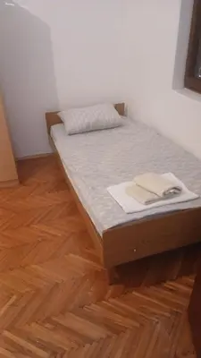 a bed in a room with a wooden floor at Apartman Lastva in Lastva