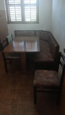 a wooden table with two chairs and a table and a window at Apartman Lastva in Lastva