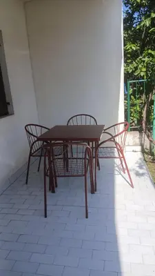a picnic table and two chairs on a patio at Apartman Lastva in Lastva