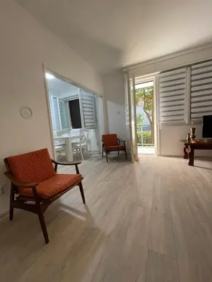 an empty living room with a chair and a television at Apartment Mijuskovic in Kravlja