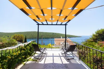 a balcony with chairs and a view of the water at Apartmani Elena in Bigovo